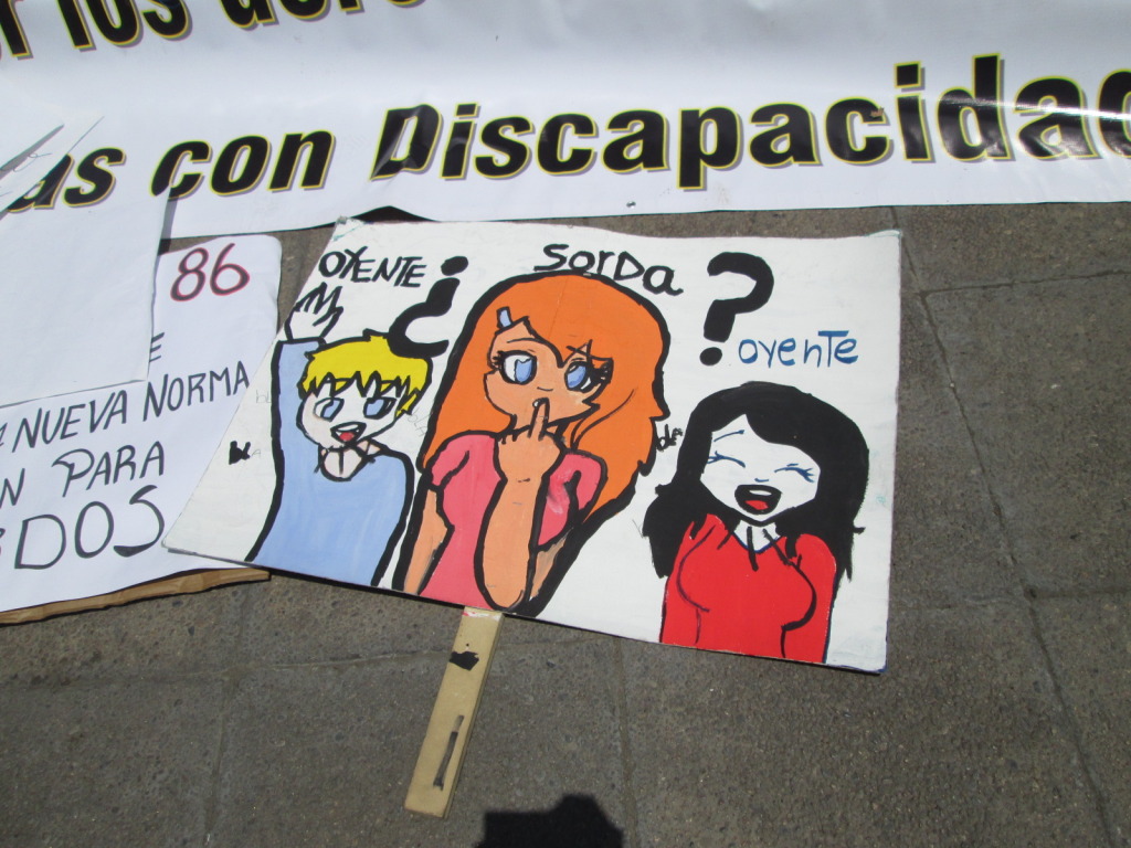 Cartel de Ascusor con dibujos de personas / © Integrados Chile 