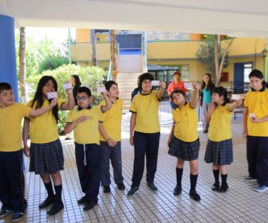 Niños y niñas mostrando sus TNE con el sello - Fuente: Twitter @EquipoJunaeb