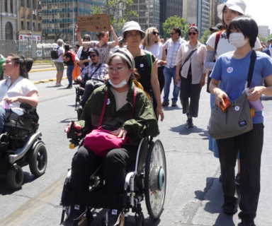 Tomoe Takekawa junto a sus dos asistentes e intérprete en marcha del 3 de diciembre por la Alameda de Santiago de Chile.